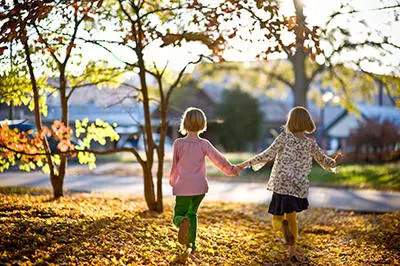 Two girls in the park hold hands